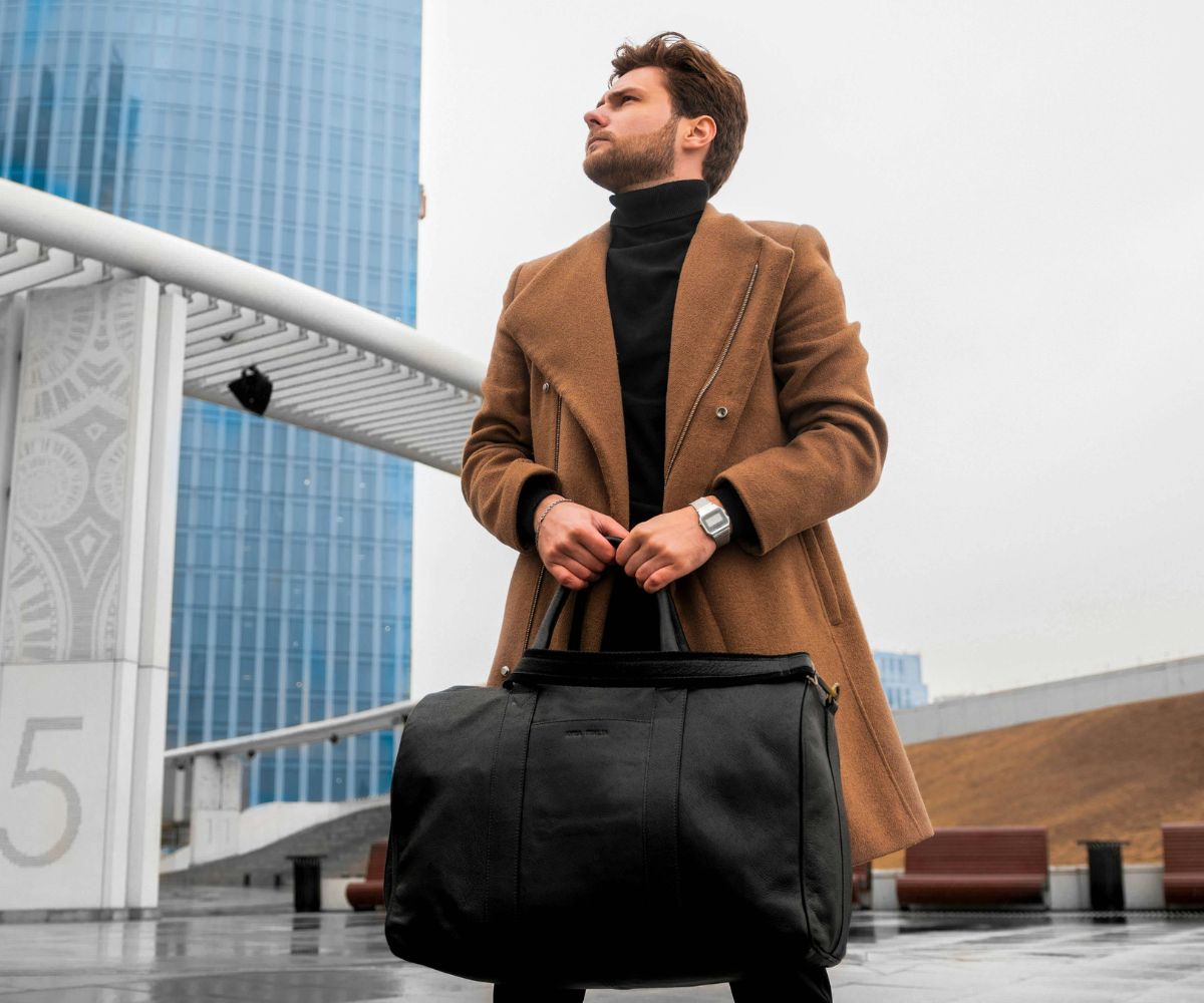 Man holding a stylish leather duffel bag